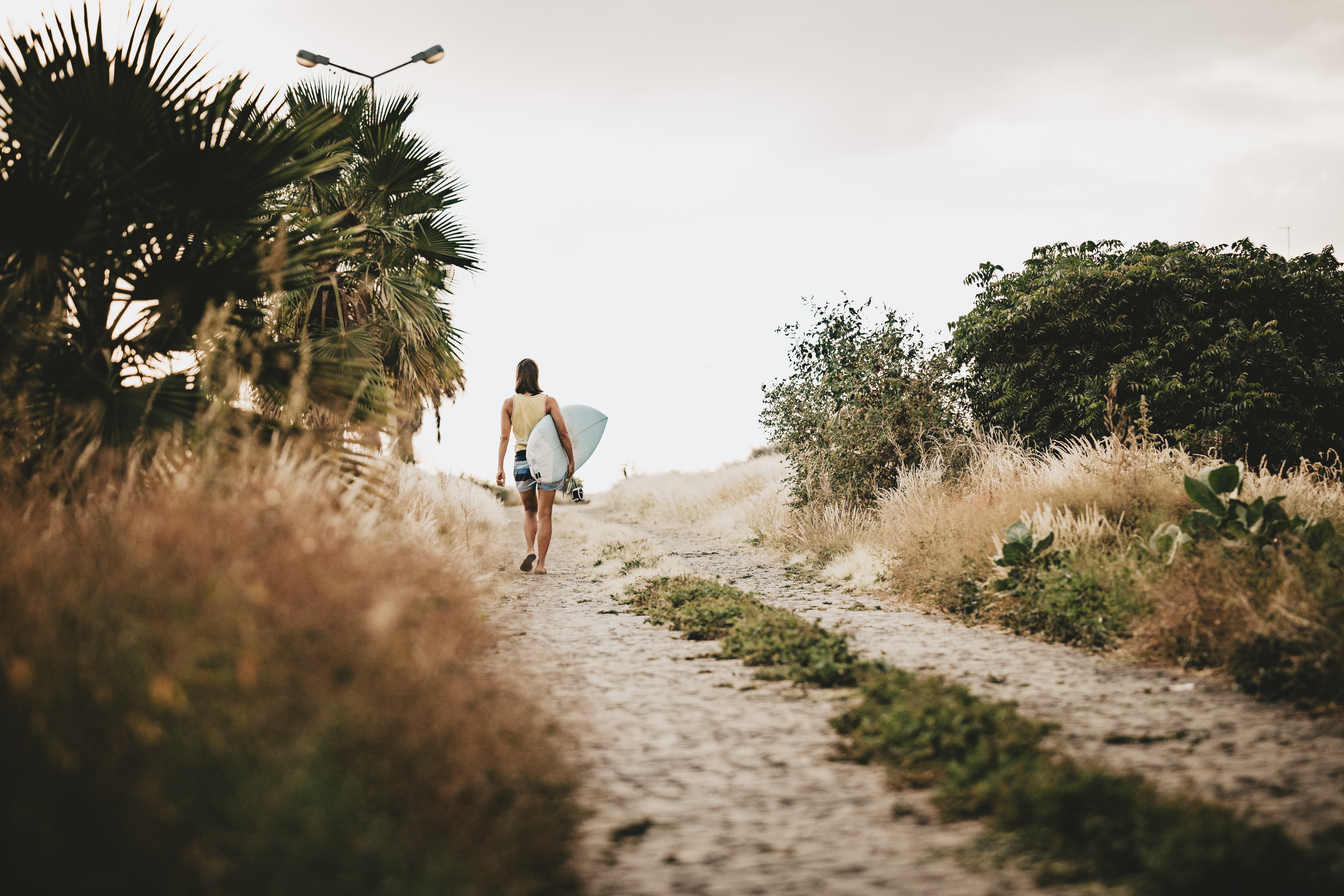 Surfer on cobblestone path